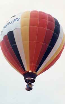 my-photo-of-a-hot-air-balloon-with-red-white-yellow-and-black--verticle-stripes--and-a-flame-shooting-up-inside-the-balloon-can-be-seen"